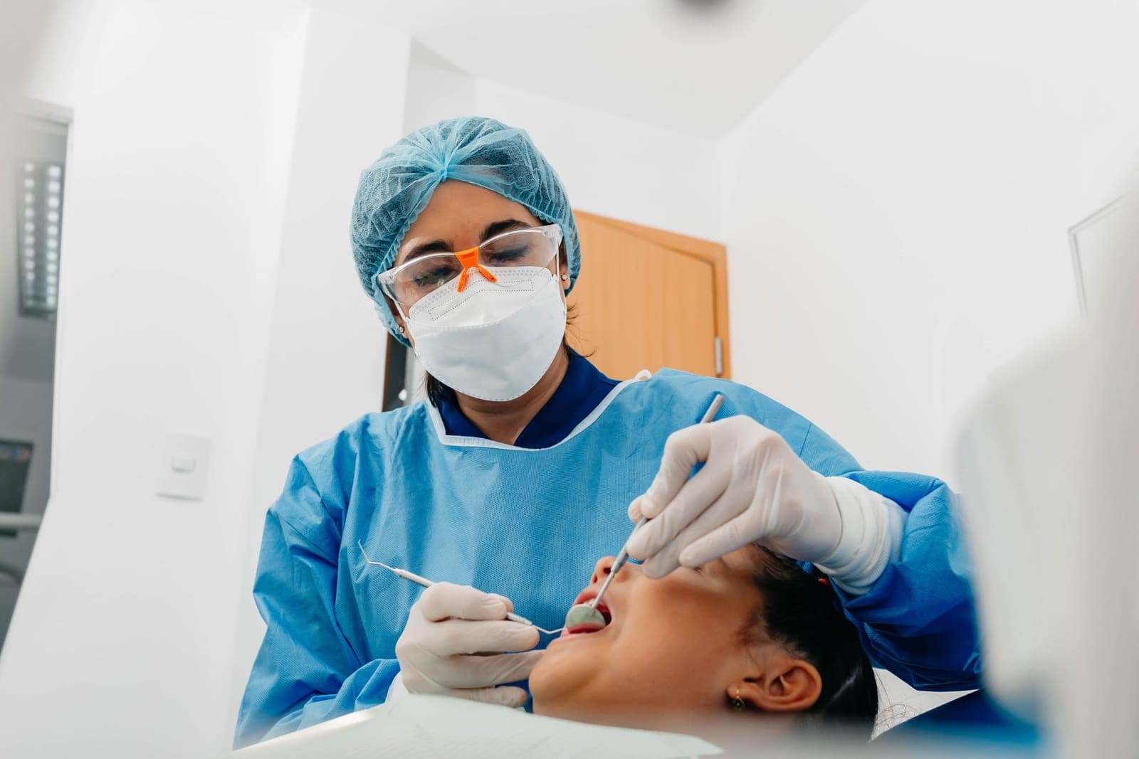A dentist checks a patient's teeth during an appointment in a private practice.