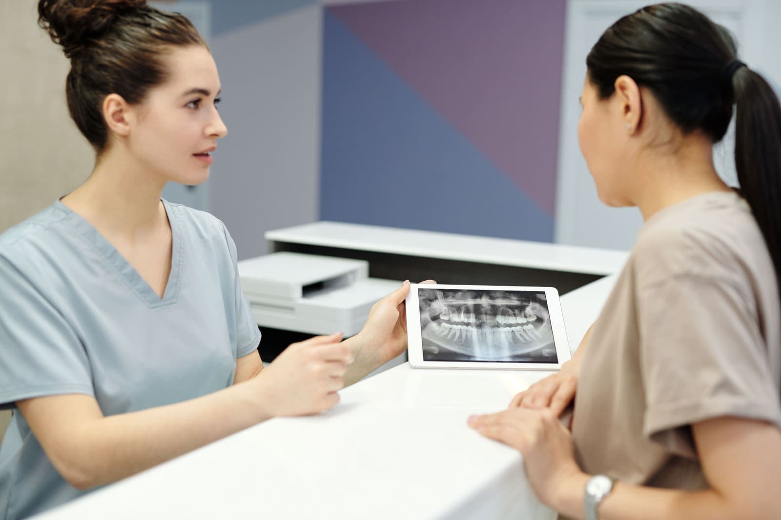 A dentist reviews dental radiographs during a consultation.
