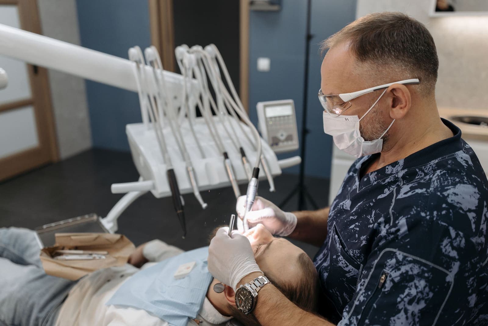 A dentist examines a patient's teeth during a clinical appointment.