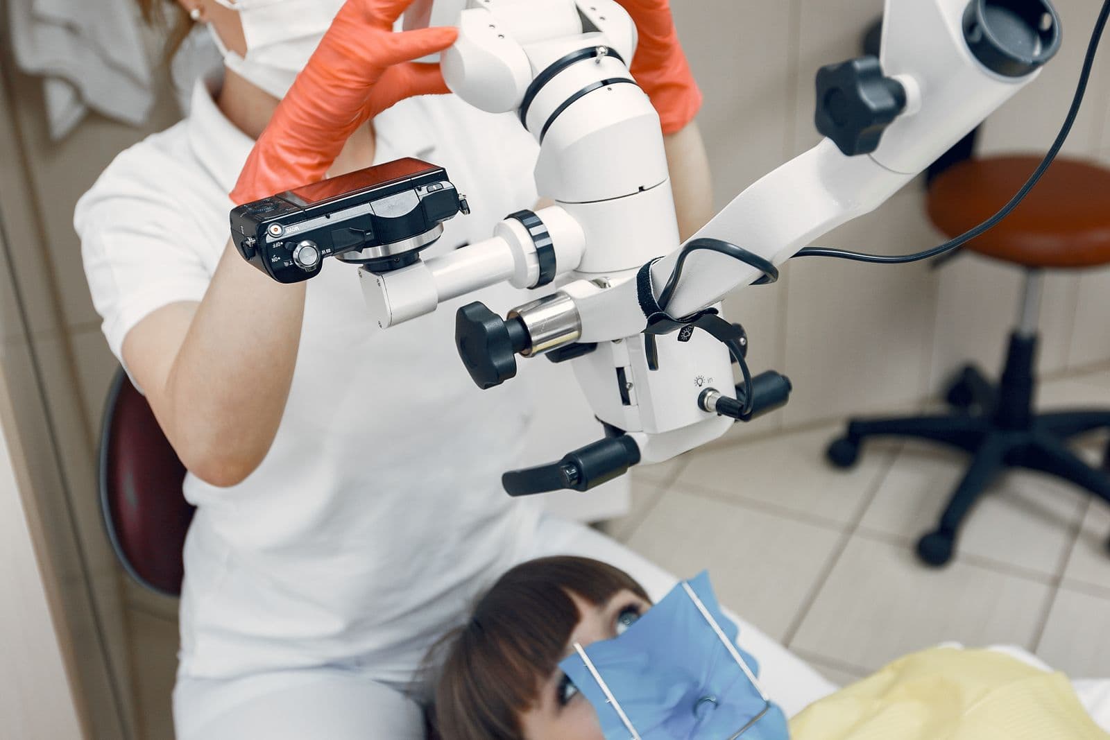 A dentist in a clinic performing a dental procedure with advanced equipment on a patient.