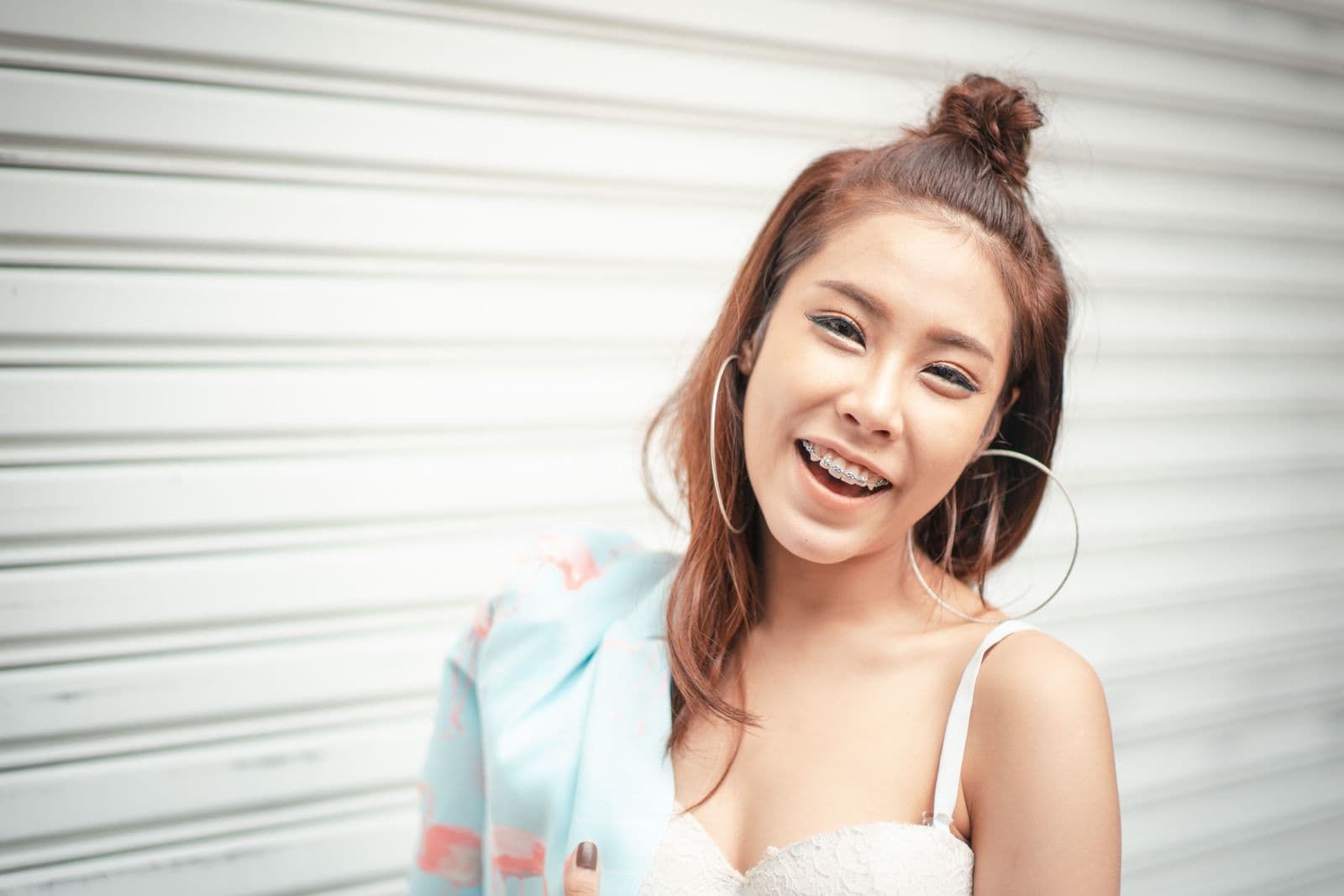 A smiling woman with braces shows her smile warmly.